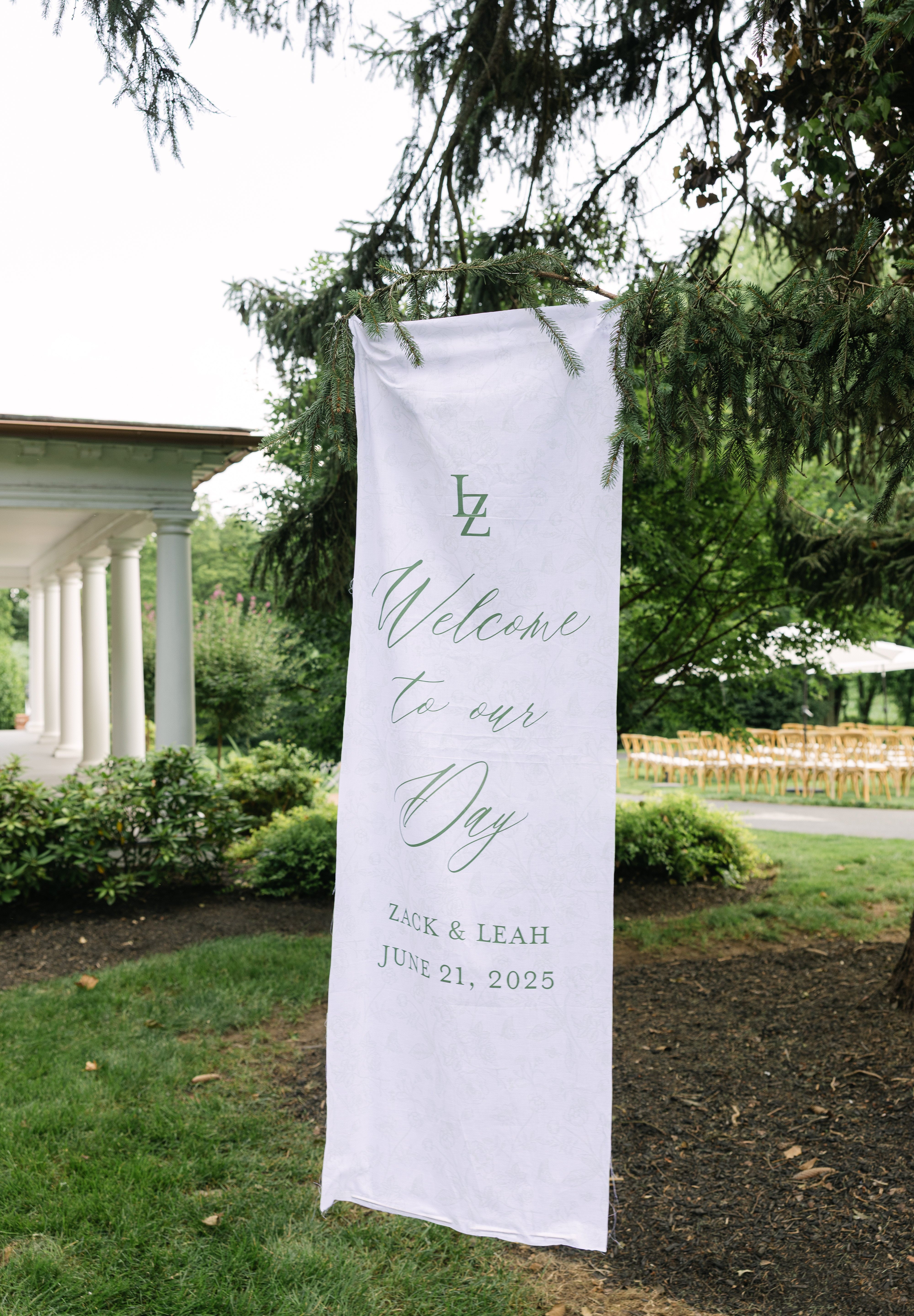 A large, white, linen banner is hung displaying a welcome sign for guests. The lettering is in green ink.