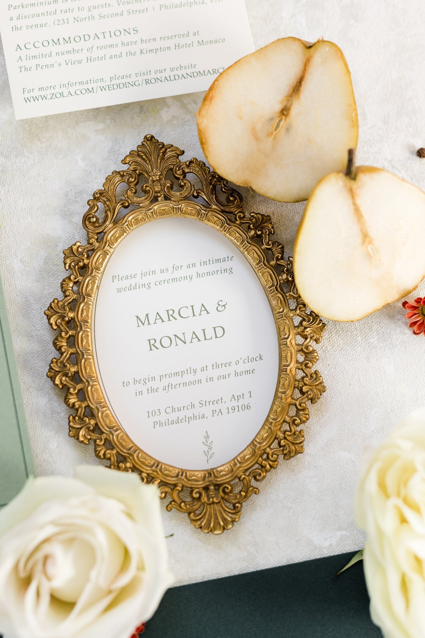 A wedding invitation framed in a golden picture frame.