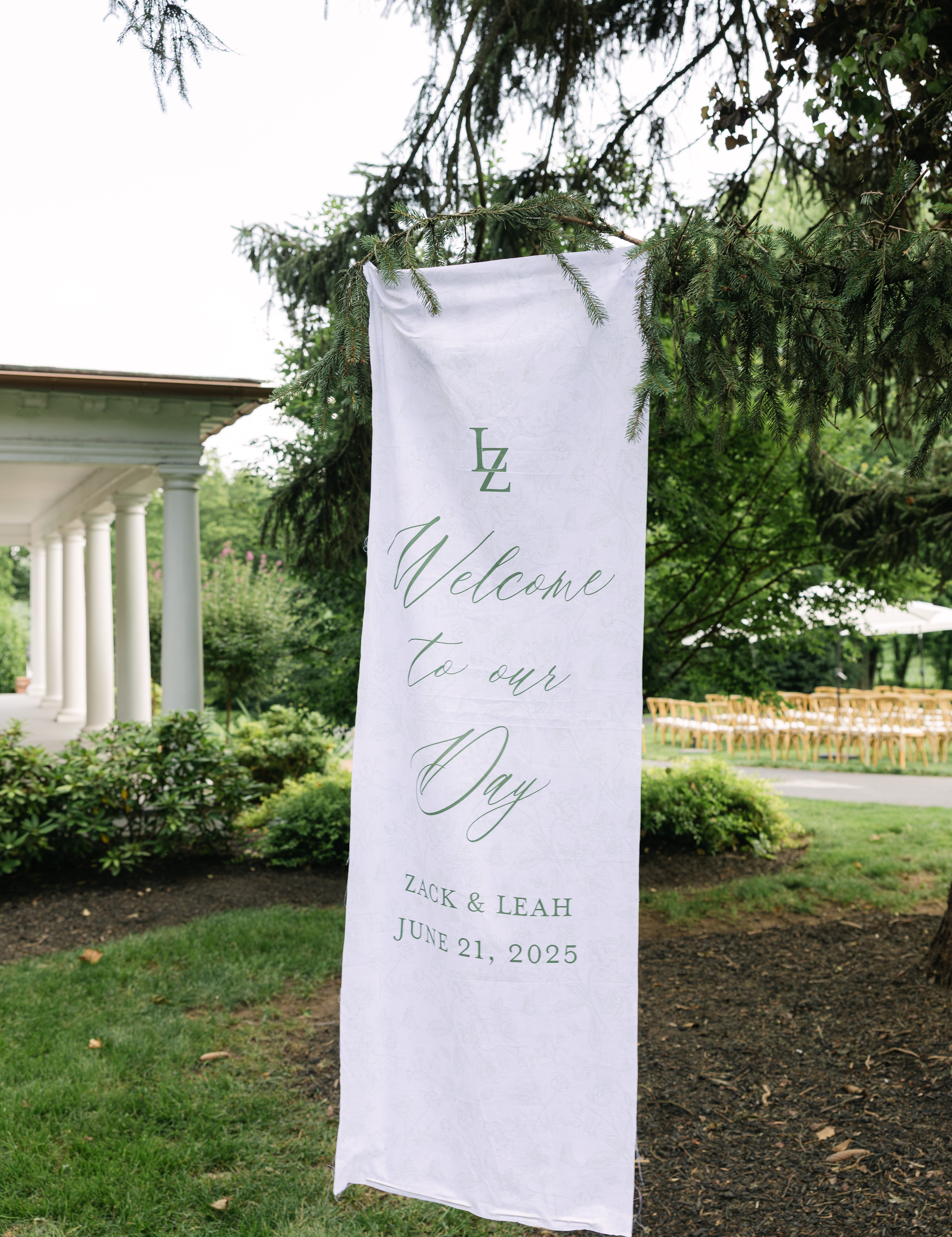 A large, white, linen banner is hung displaying a welcome sign for guests.  The lettering is in green ink.