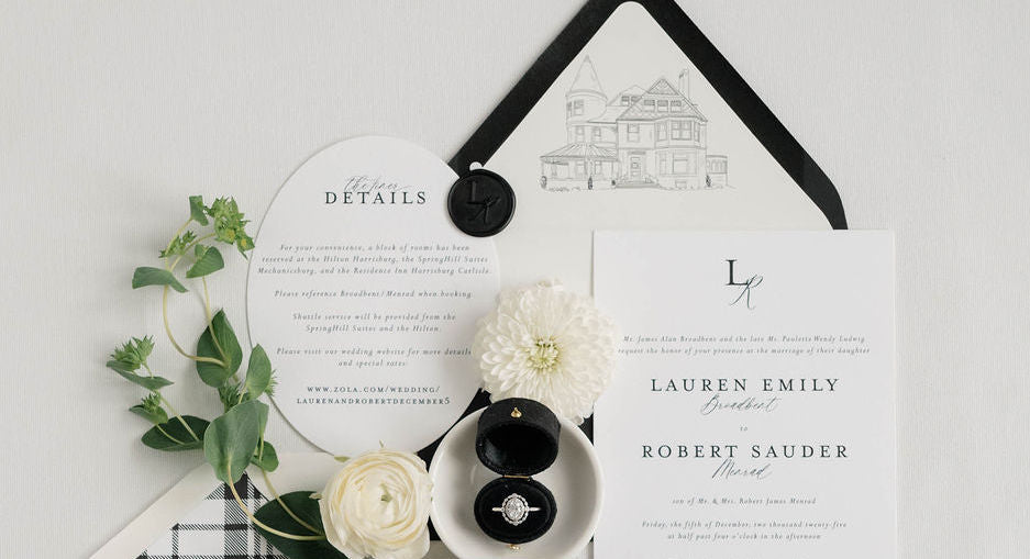 A flatlay of a black and white invitation suite. 