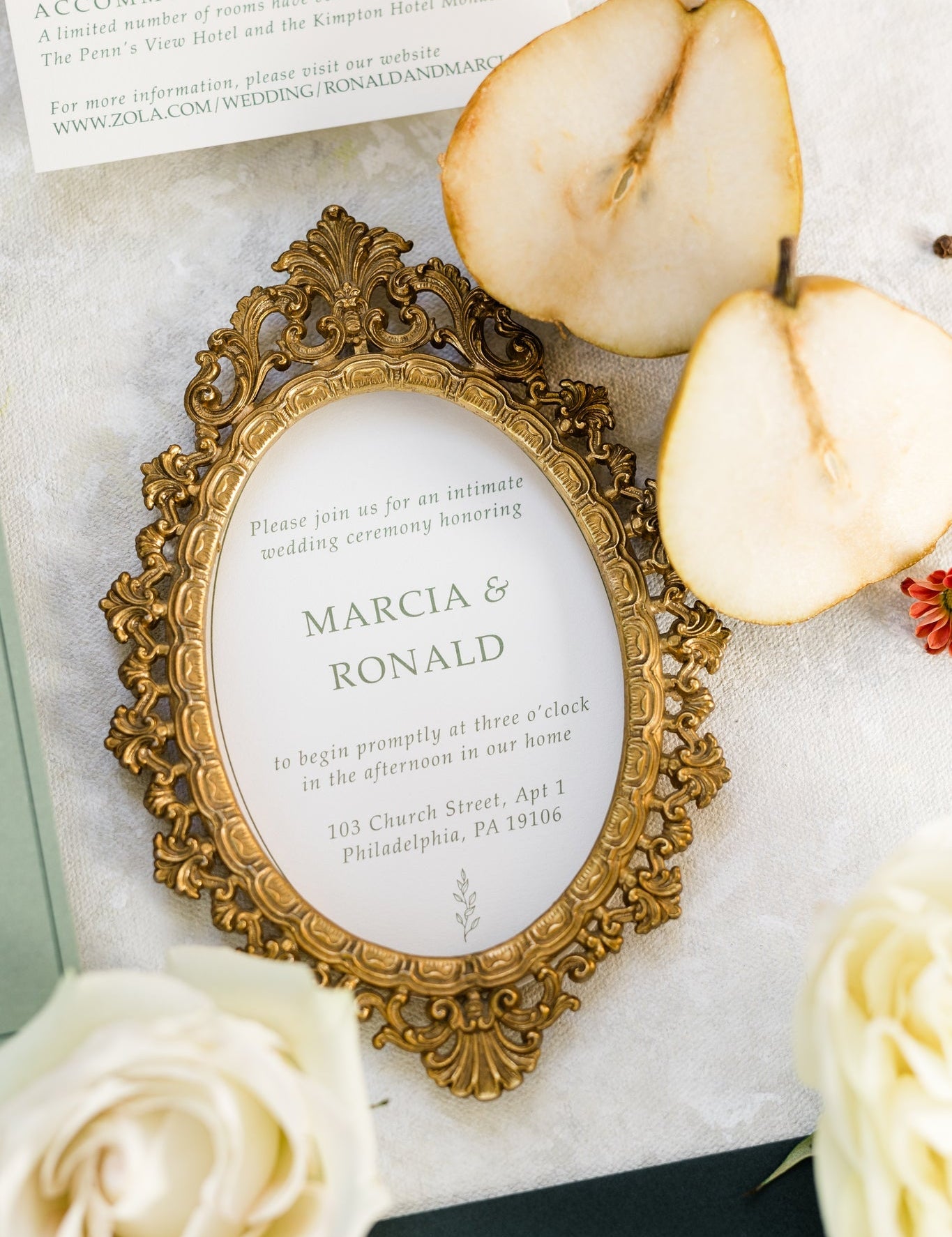 A wedding invitation framed in a golden picture frame.