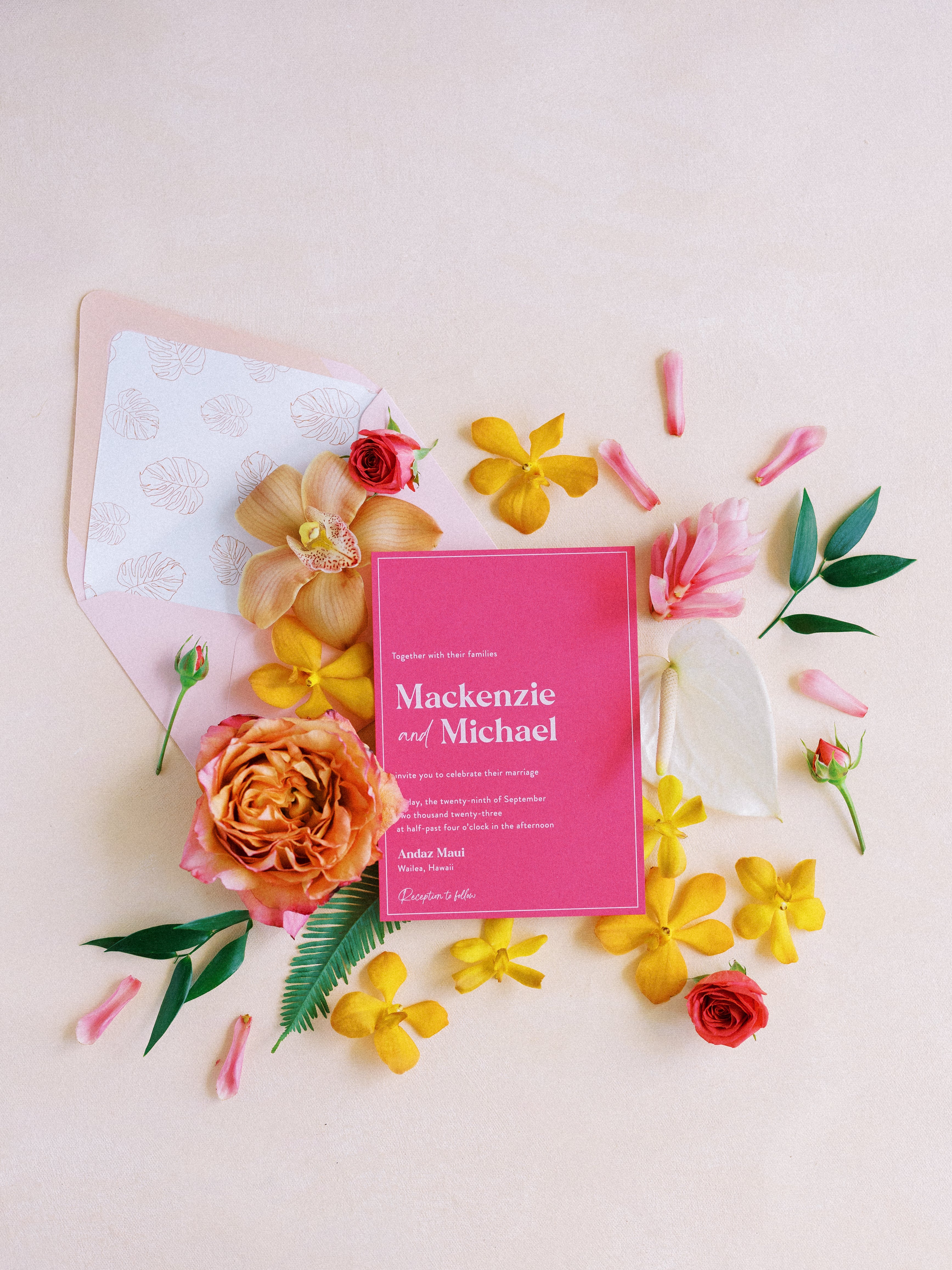 magenta wedding invitation with white ink and tropical flowers on a white background