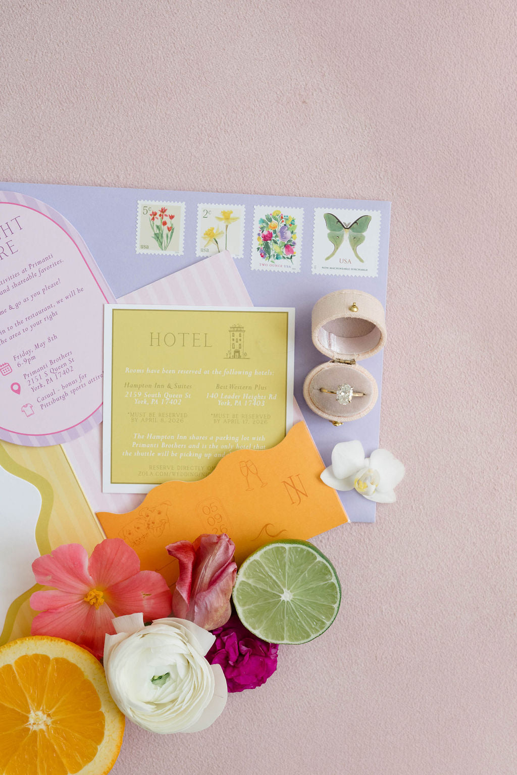 Colorful stationery set with flowers and citrus on a pink background
