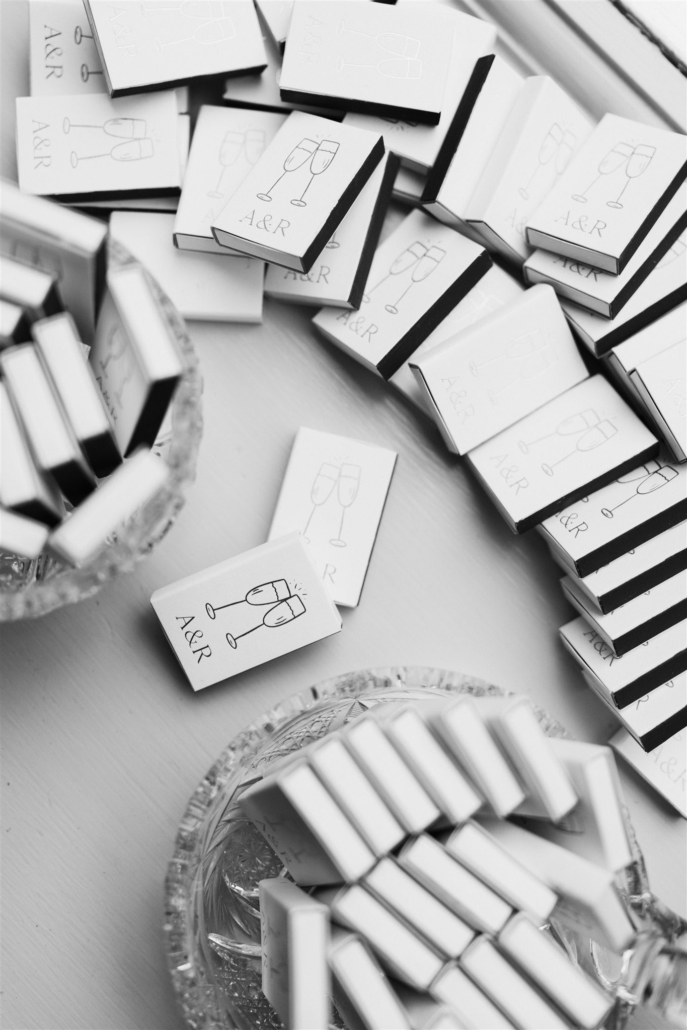 Stacks of white matchbooks with black text and design on a light gray background