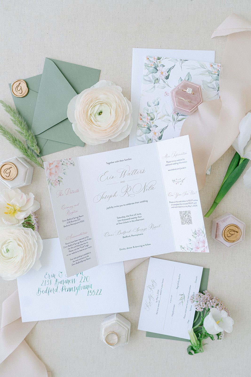 sage and pink wedding invitation cards laid out on a beige background with wax seals