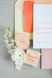Wedding invitation set with flowers and seals on a gray surface