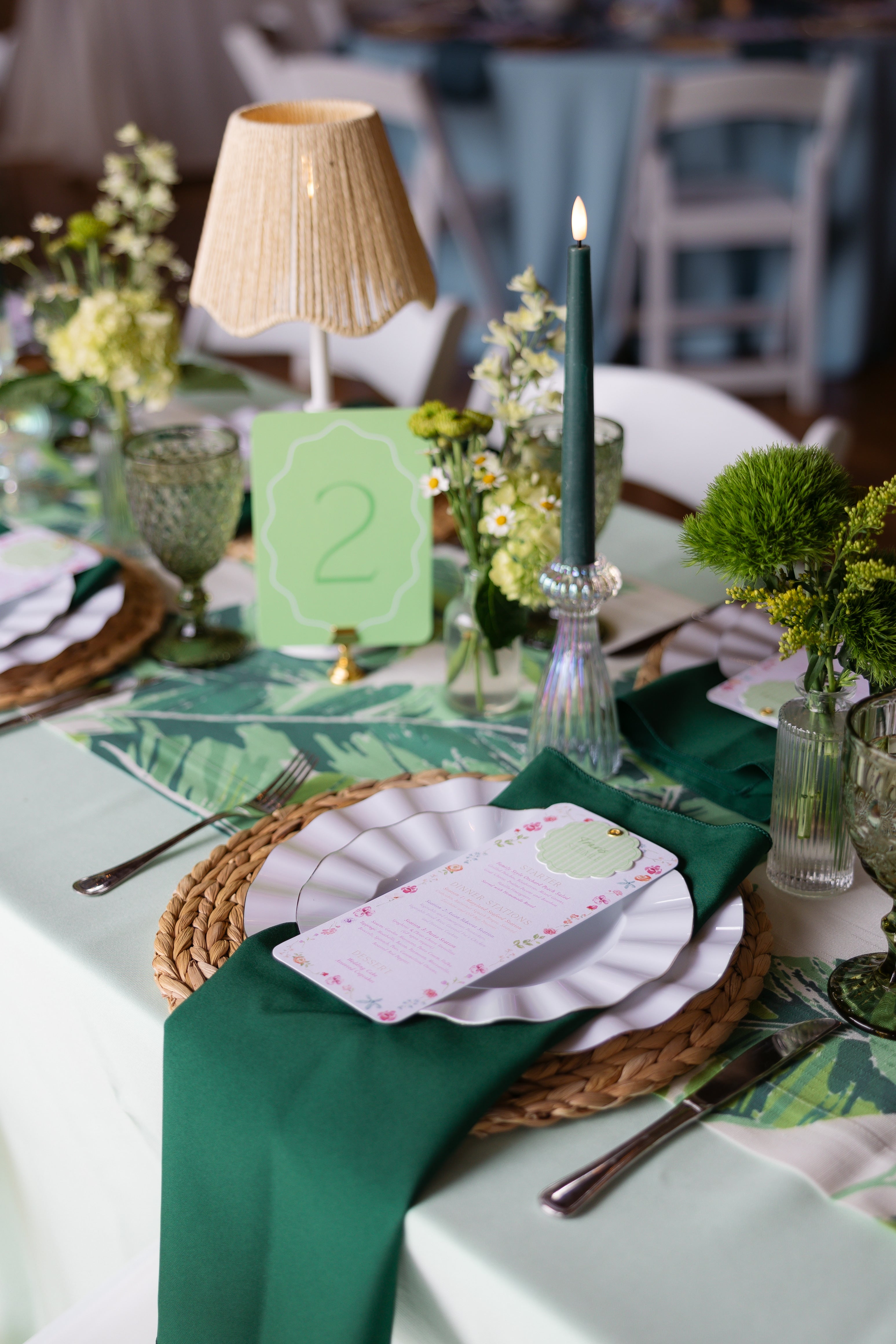 Elegant table setting with green tablecloth, floral centerpieces, and decorative elements.