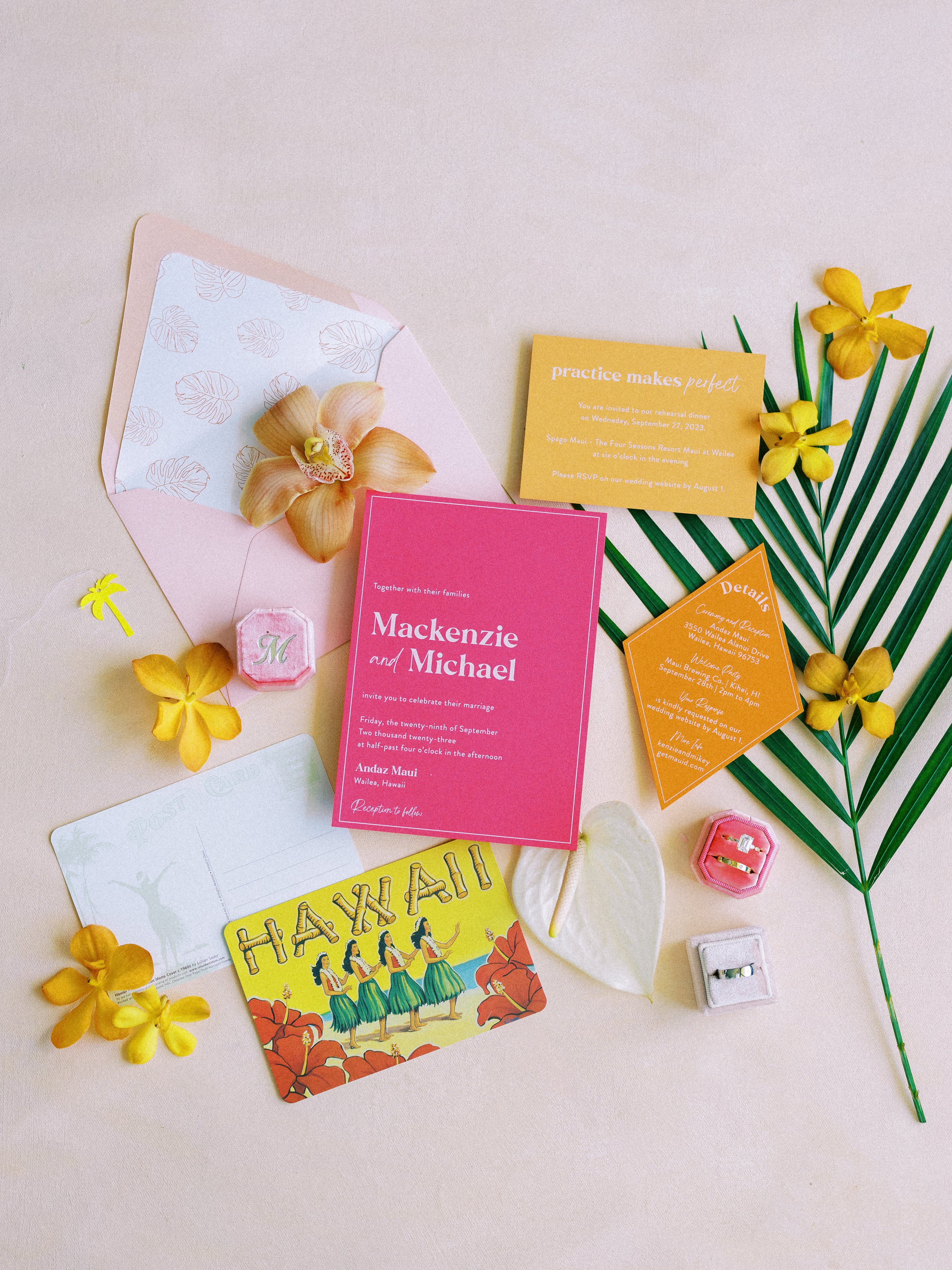 tropical wedding invites with orange and pink cards and tropical flowers and greens 