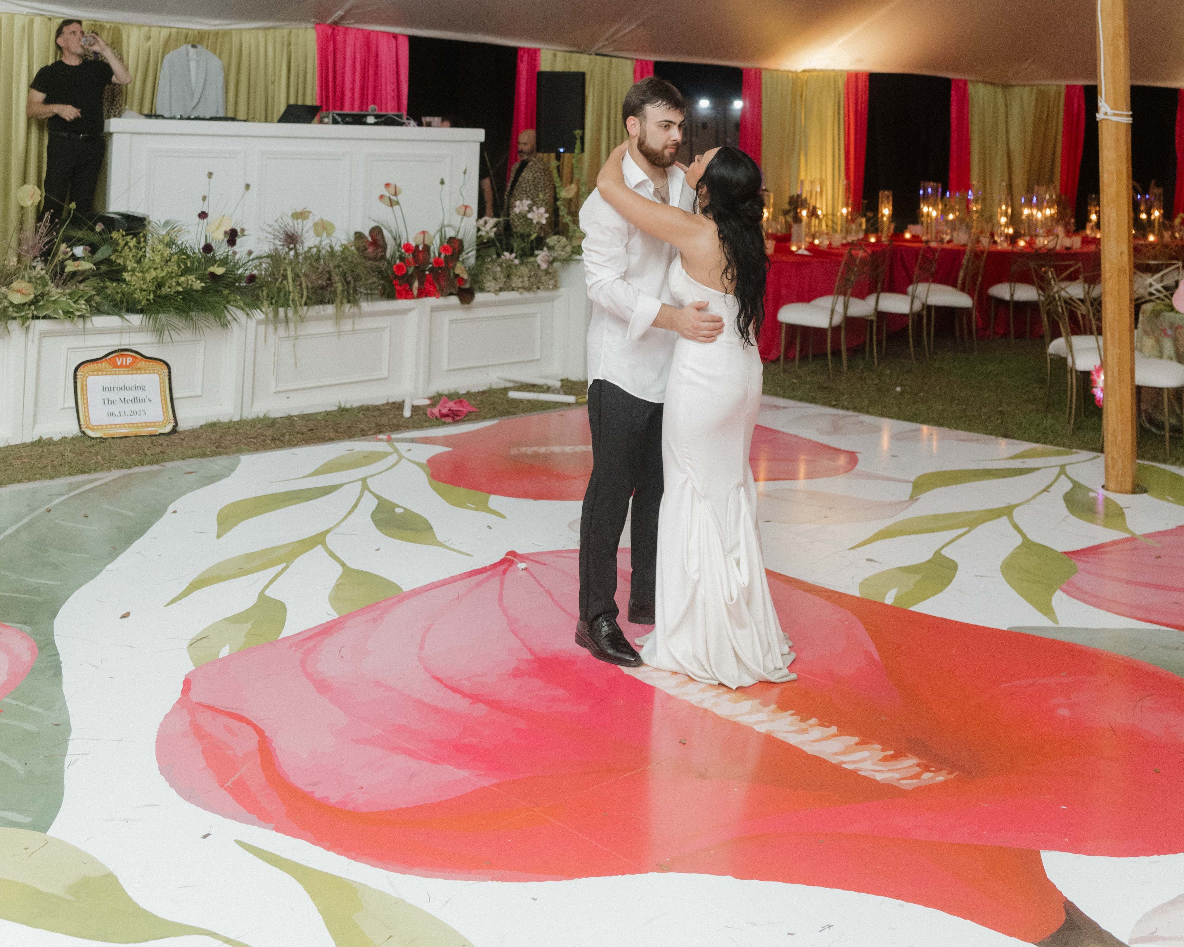 Couple dancing in a decorated indoor setting with floral patterns on the floor
