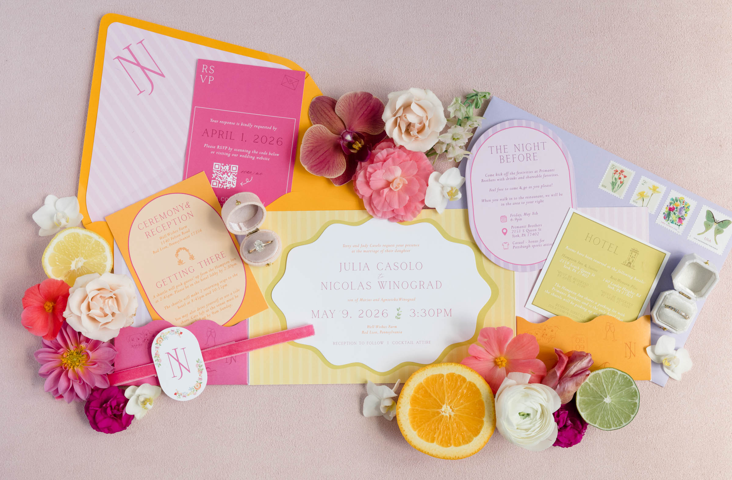Colorful stationery set with flowers and citrus fruits on a light pink background