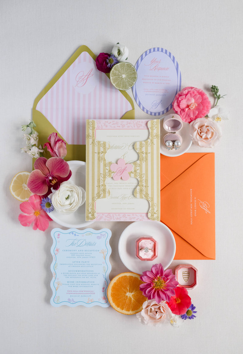 Colorful stationery set with envelopes, cards, and flowers on a light gray background