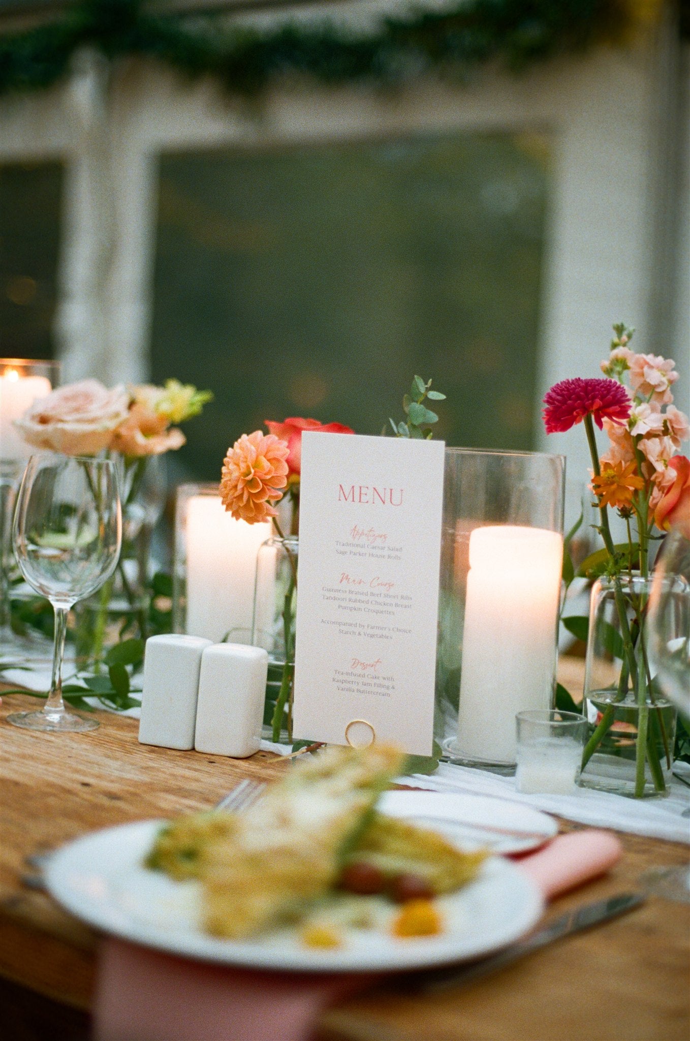 Decorative table setting with flowers, candles, and a menu card.